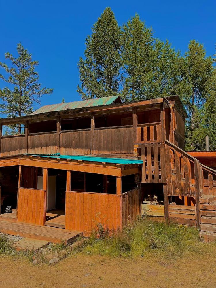 Двухэтажный дом. В беседке-веранде холодильник.