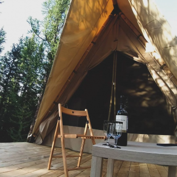 Терраса лесного шатра со столиком и стульями