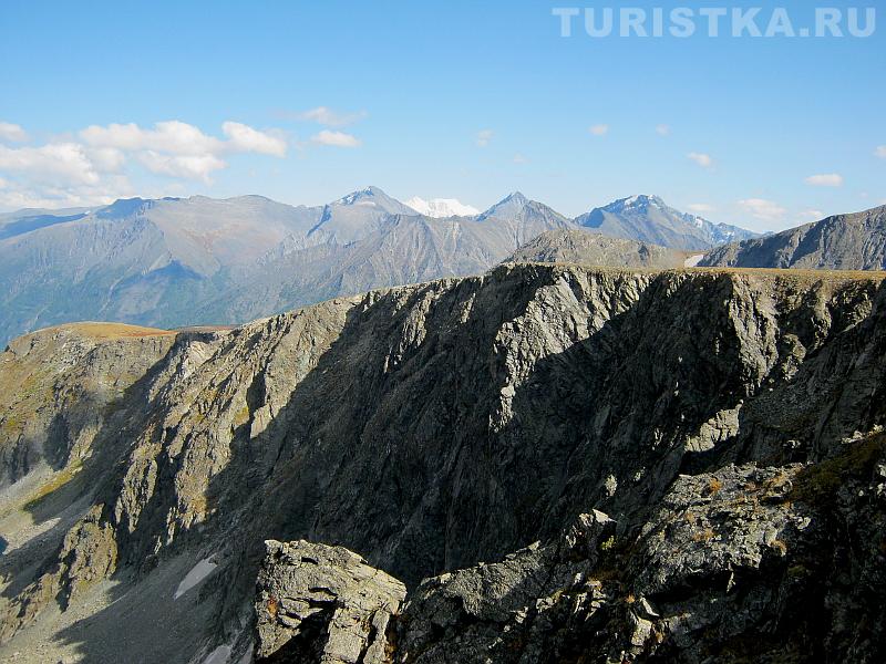 Скальный обрыв к озеру и Белуха на горизонте