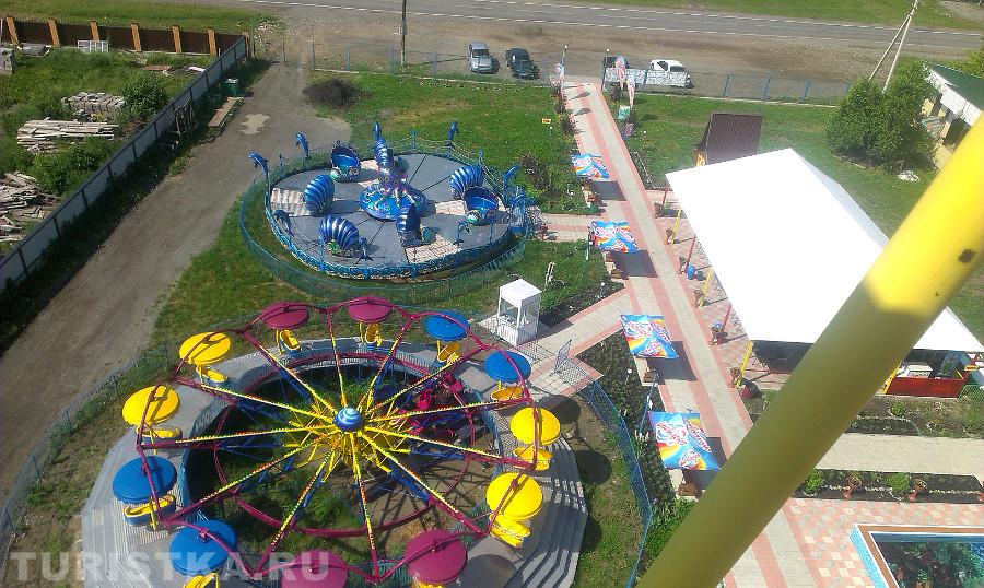 Вид с колеса обозрения на парк аттракционов
